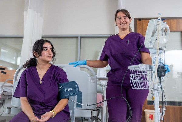 Two female nursing students practicing taking blood pressure