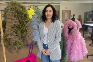 woman standing next to her sewn work