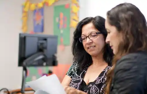 two women looking at a document